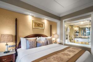 a bedroom with a large bed and a large mirror at Green Lake Hotel in Kunming