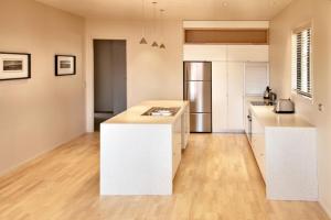 a kitchen with white counters and a refrigerator at Dragonfly Cottage in Wanaka