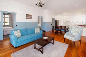 a living room with a blue couch and a table at McDougall Cottage in Wanaka