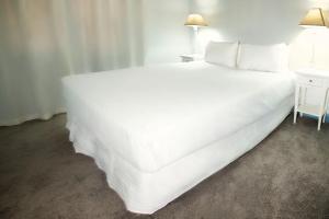a large white bed in a room with a table at McDougall Cottage in Wanaka