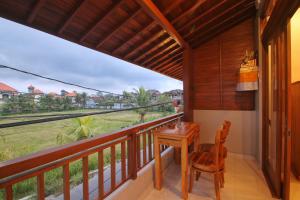 a balcony with a desk and a view of the train at Sari Bungalow in Ubud