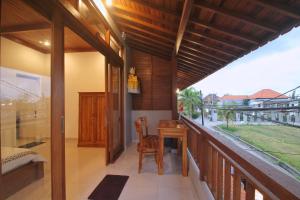 a balcony of a house with a table and a desk at Sari Bungalow in Ubud +9 photos