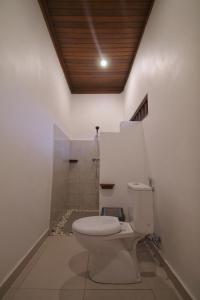 a bathroom with a toilet and a shower at Sari Bungalow in Ubud