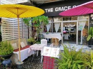 una mesa con una sombrilla amarilla frente a una cafetería en The Grace House Chiangmai, en Chiang Mai