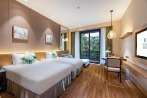 武夷山市にあるC&D Resort,Wuyi Mountainのベッド2台とテレビが備わるホテルルームです。