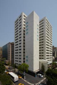 deux grands bâtiments blancs dans une ville dans l'établissement Gloria Residence, à Taipei