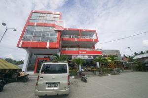 a small car parked in front of a building at RedDoorz Plus Syariah @ Pentadio Gorontalo in Gorontalo