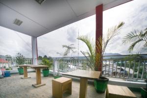 a balcony with two benches and a large window at RedDoorz Plus Syariah @ Pentadio Gorontalo in Gorontalo