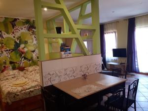 a room with a bed and a table with chairs at Rozmaring Apartmanok in Gyula