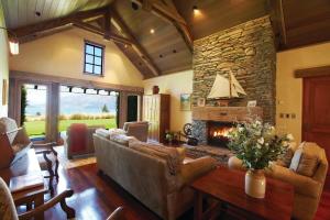 a living room with a couch and a fireplace at Blanket Bay in Glenorchy