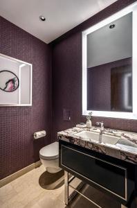 a bathroom with a toilet, sink and mirror at The Darling at The Star Gold Coast in Gold Coast