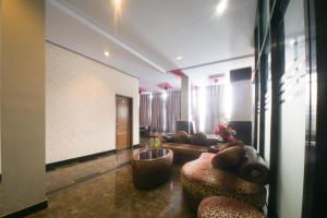a living room with couches and chairs in a room at RedDoorz near TVRI Gorontalo in Telaga