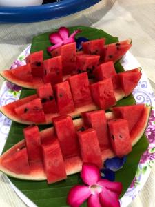 two slices of watermelon on a green leaf with flowers at The Mountain View Hat Sai Ri Resort in Ban Hat Sai Ri (1)