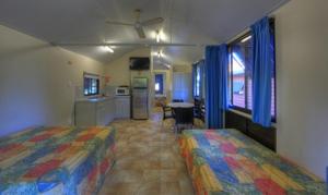 a bedroom with a bed and a television at Kookaburra Holiday Park in Cardwell
