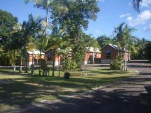 a large white house with trees at Kookaburra Holiday Park in Cardwell