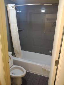 La salle de bains est pourvue de toilettes, d'une baignoire et d'une douche. dans l'établissement Budget Inn Of Orlando, à Orlando