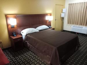 Budget Inn Of Orlando في أورلاندو: غرفة في الفندق سرير كبير مع وسادتين
