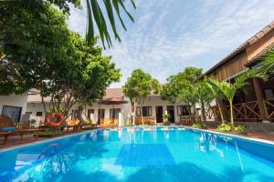 una piscina en un complejo con sillas y árboles en Phu Quoc Villa, en Phu Quoc