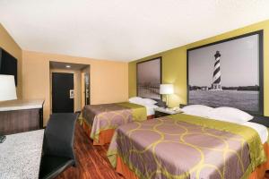 a hotel room with two beds and a large window at Super 8 by Wyndham Raleigh North East in Raleigh