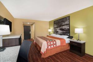 een hotelkamer met een groot bed en een bureau bij Super 8 by Wyndham Raleigh North East in Raleigh