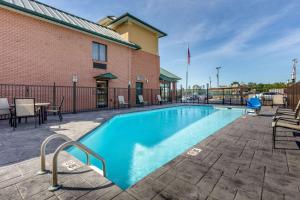 a swimming pool with tables and chairs next to a building at Comfort Inn in Lenoir City