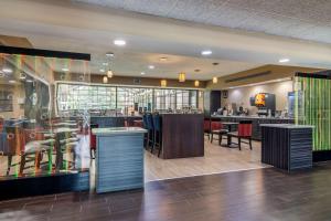 un restaurante con un bar con mesas y sillas en Comfort Inn & Suites Perry National Fairgrounds Area, en Perry