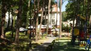 a playground in a park with trees and a building at APARTAMENT MARZENA in Świnoujście