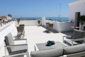 a patio with a couch and chairs on a roof at Sant'Eufemia Rooms Self Check in in Vieste