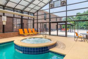 bañera de hidromasaje en un edificio con sillas y mesa en Comfort Inn & Suites Perry National Fairgrounds Area, en Perry