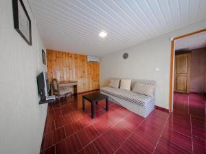a living room with a couch and a tv at Alexander Bungalows in Shkorpilovtsi