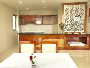 a kitchen with a table and chairs and a counter at Windy Hotel Quang Binh in Dong Hoi