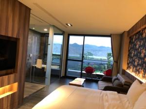 a bedroom with a bed and a living room with a view at Tan Villa in Taitung City