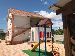 a playground in front of a house with a slide at Mini-hotel Zefir in Zatoka