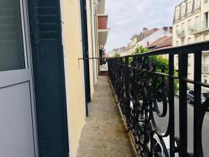 d'un balcon avec une balustrade noire et une rue. dans l'établissement Villa Tarbis Tarbes centre ville , appartements tout confort, à Tarbes