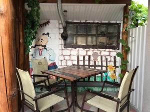 a table and chairs with a painting on the wall at Mini-hotel Zefir in Zatoka