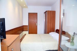 - une petite chambre avec un lit et un miroir dans l'établissement Apartments Ardura, à Petrovac na Moru