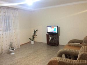 a living room with a flat screen tv and chairs at Apartment in Gagra in Gagra