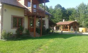 een huis met een veranda en een tuinhuisje bij Katalin Kulcsosház in Kiruj Fürdő