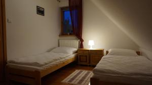 two twin beds in a room with a window at Pod Kasztanami in Międzylesie