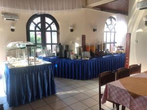 ハイドゥソボスローにあるKarikas Hotelの青いテーブルクロス付きの部屋