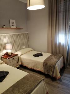 a hotel room with two beds and a lamp at Casa Marina in Caldas de Reis