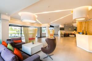 a living room with a couch and a chair at Hotel J Residence Pattaya - SHA Extra Plus in Pattaya