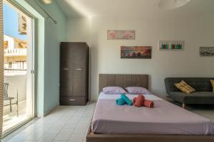 een slaapkamer met een bed en een bank bij 3rd Floor Apartment next to the BeachFront in Heraklion