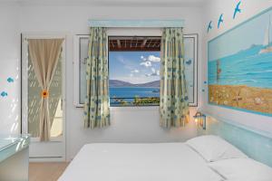 a bedroom with a bed and a view of the ocean at Haraki Memories Beach Studios in Haraki