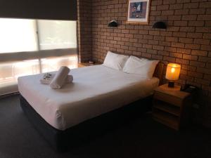 A bed or beds in a room at Cessnock Vintage Motor Inn