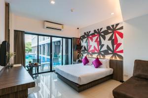 1 dormitorio con cama con almohadas rosas y sofá en Hotel J Residence Pattaya, en Pattaya central 128 fotos más