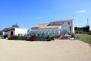 ein Gebäude mit einem Gewächshaus aus Glas neben einem Haus in der Unterkunft L'EDEN DE LA HAUTE FORET in Mervent