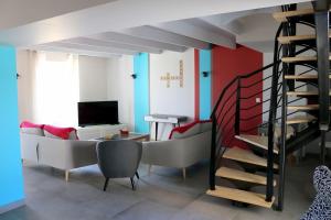 ein Wohnzimmer mit einer Couch und einer Treppe in der Unterkunft L'EDEN DE LA HAUTE FORET in Mervent