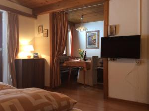 Schlafzimmer mit einem Bett, einem Tisch und einem TV in der Unterkunft Alpbach Apartments in Reith im Alpbachtal