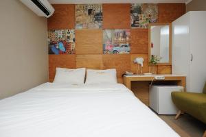 ソウルにあるホテル ミド ミョンドンのベッドルーム(白い大型ベッド1台、デスク付)